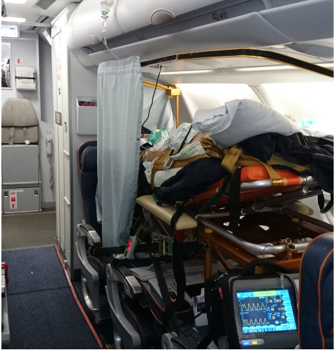 Пациент на носилках в самолете с подключенной аппаратурой